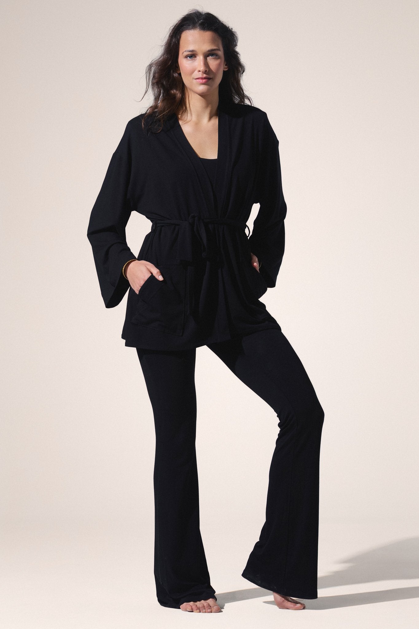 Woman wearing a black outfit on a plain background