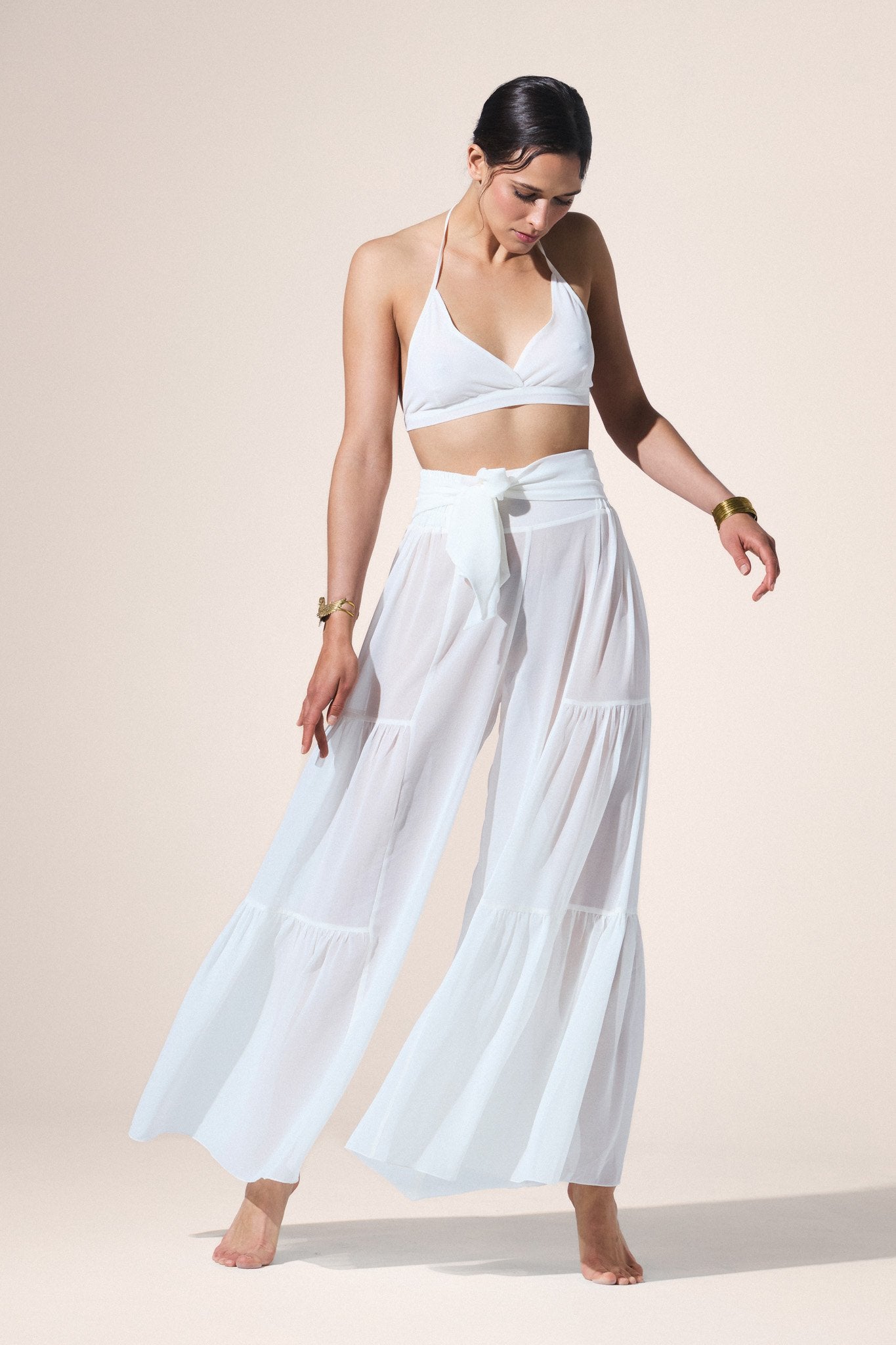 Woman wearing a white outfit with a beige background