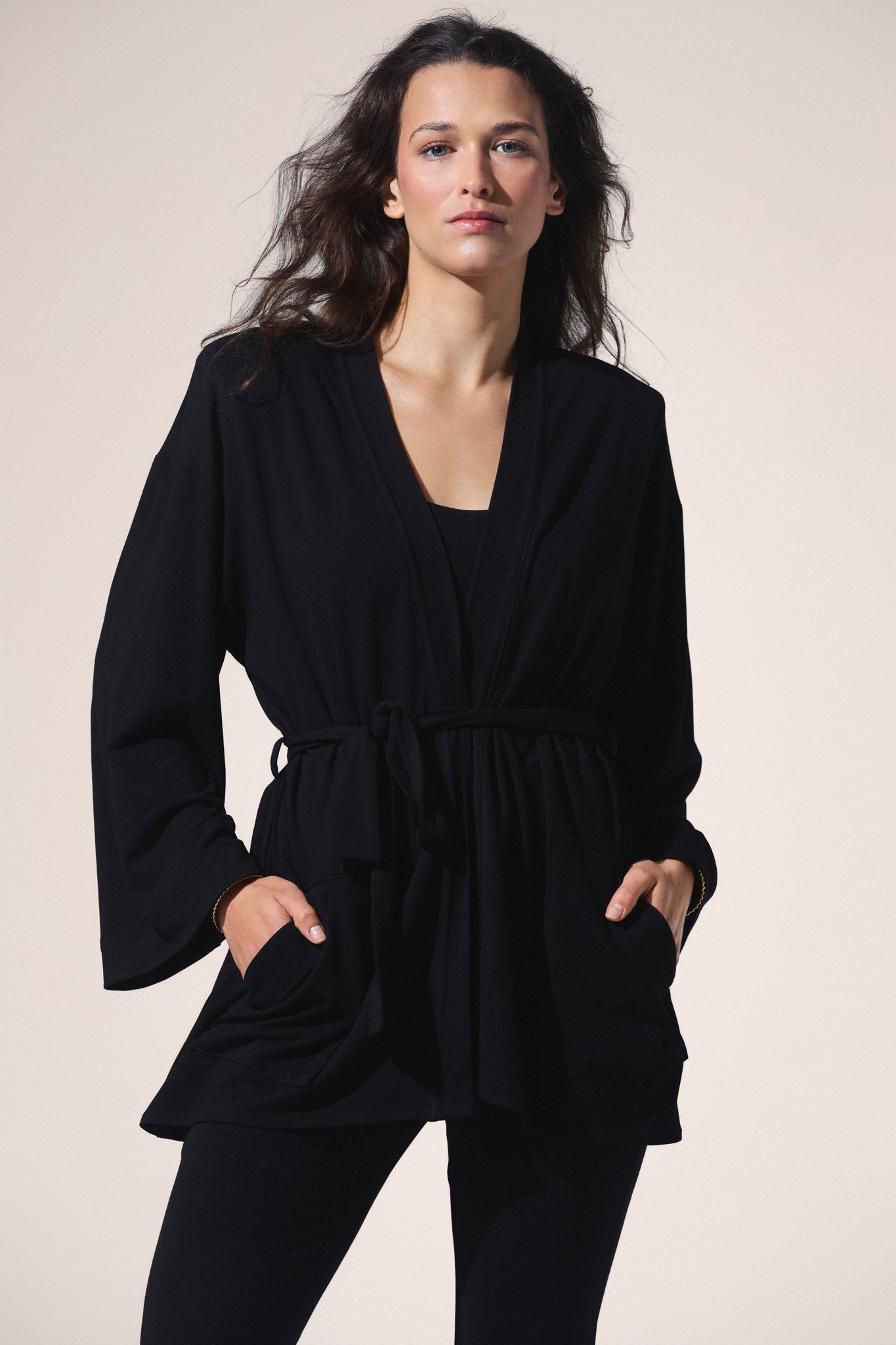 Woman wearing a black outfit against a plain background