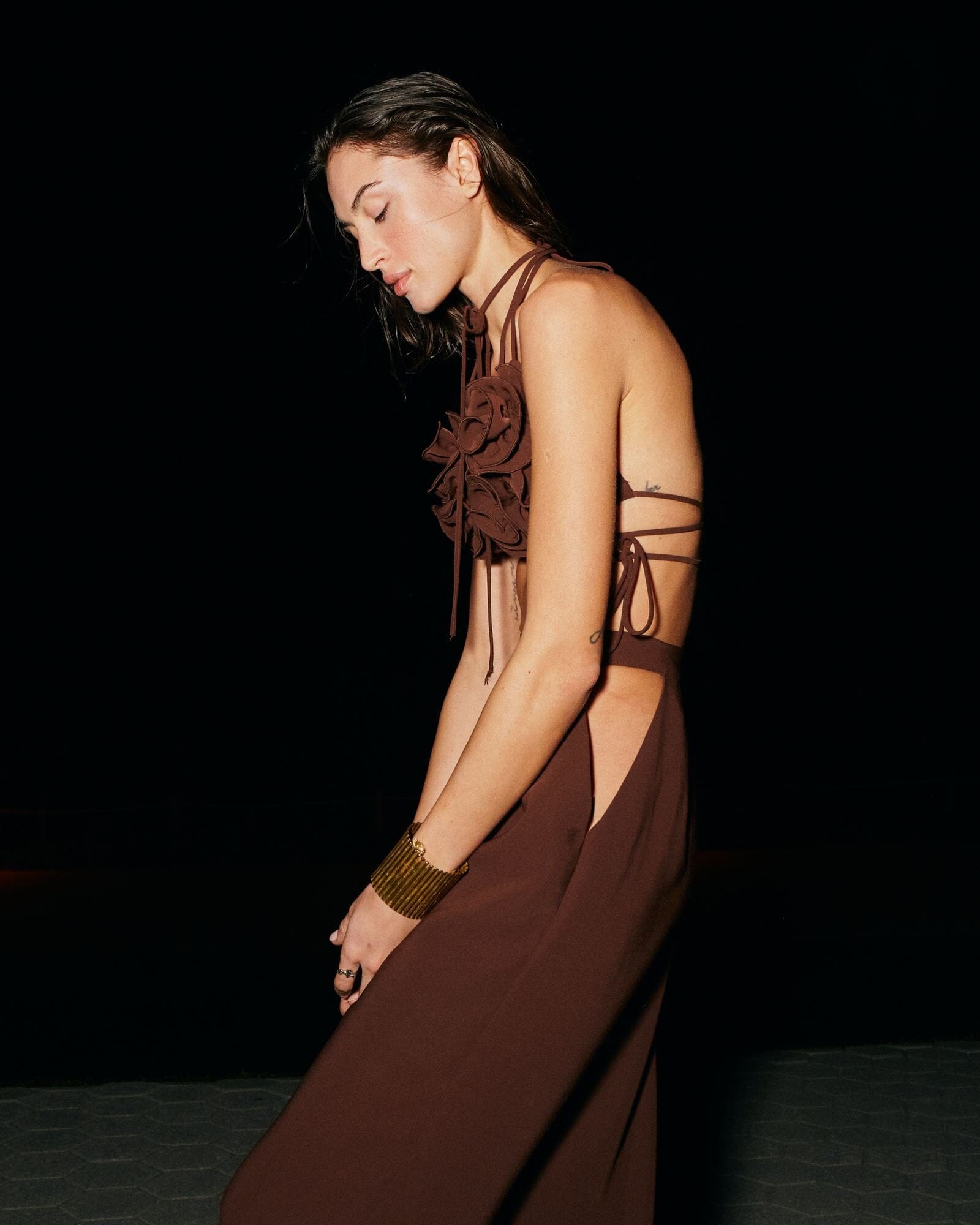 Woman wearing a brown dress with cut-out design on a black background