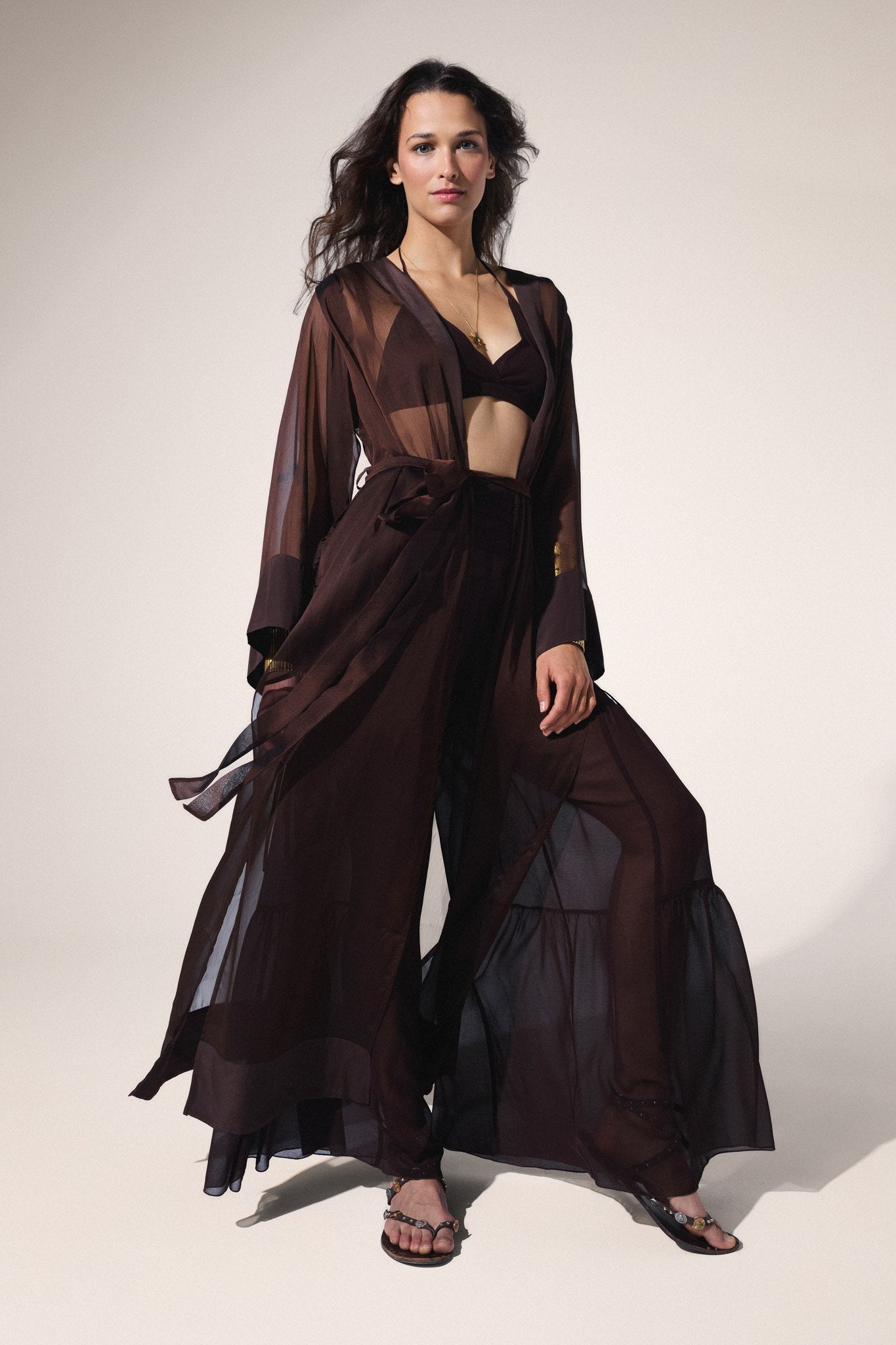 Woman wearing a dark brown sheer outfit on a white background