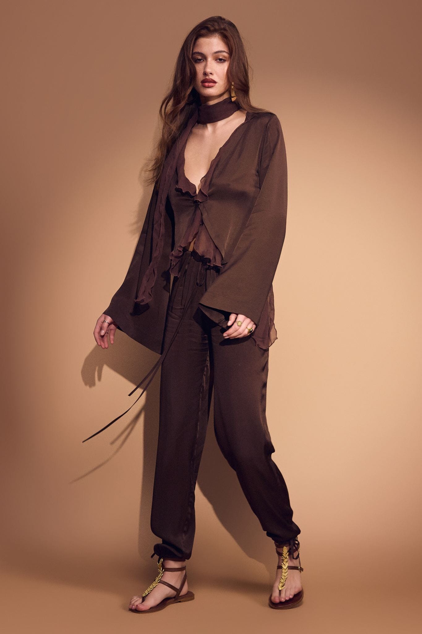Woman wearing a brown outfit against a beige background