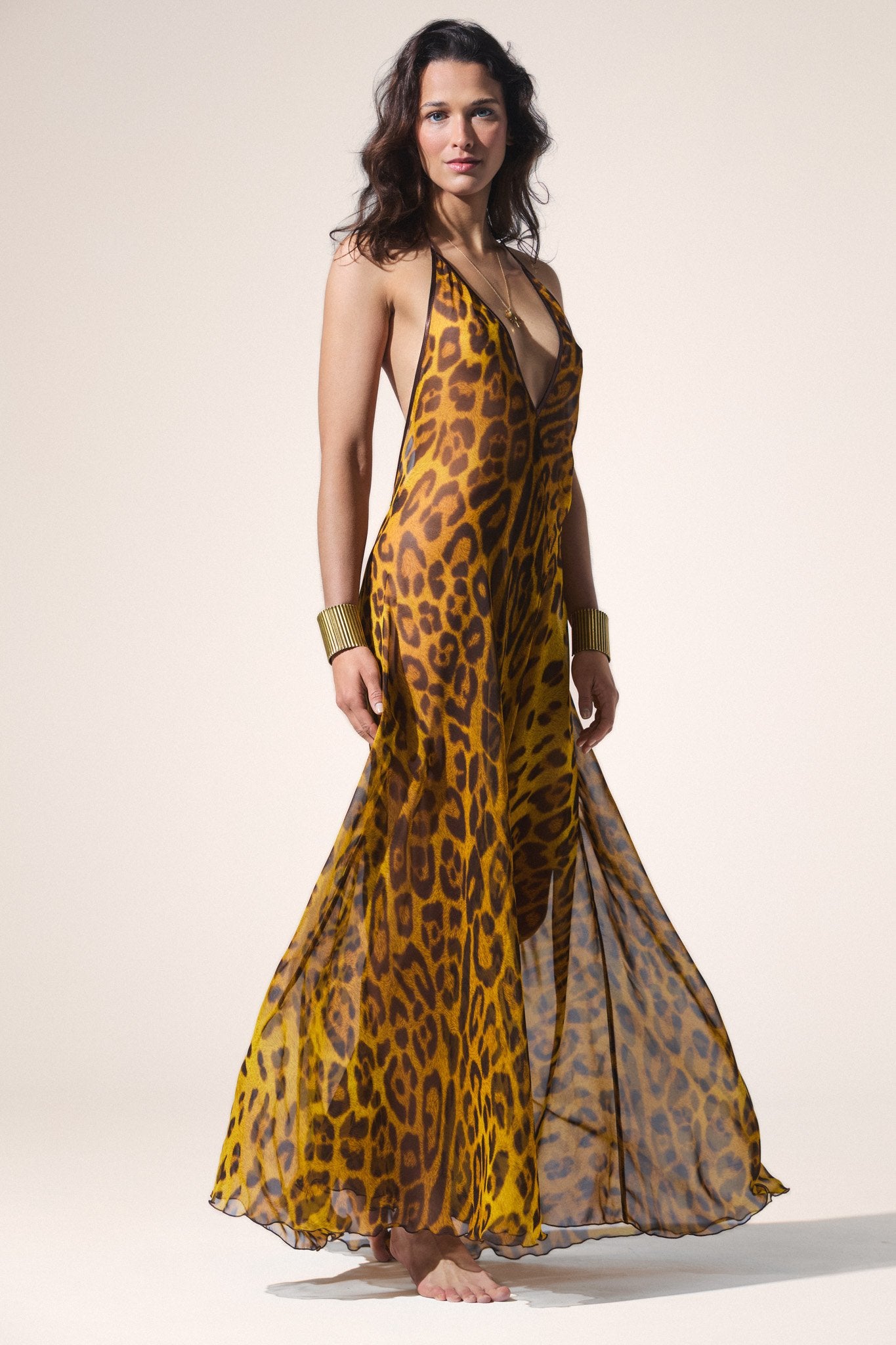 Woman wearing a cheetah print dress on a white background